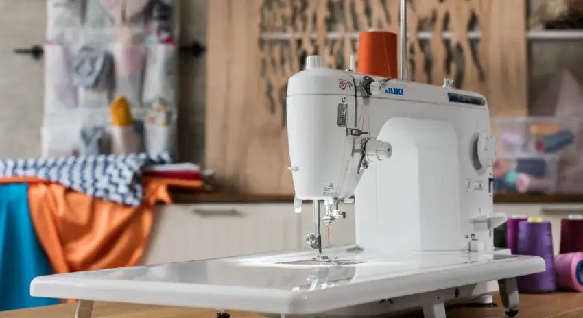 Juki home sewing machine with extended work table with various sewing supplies in the background