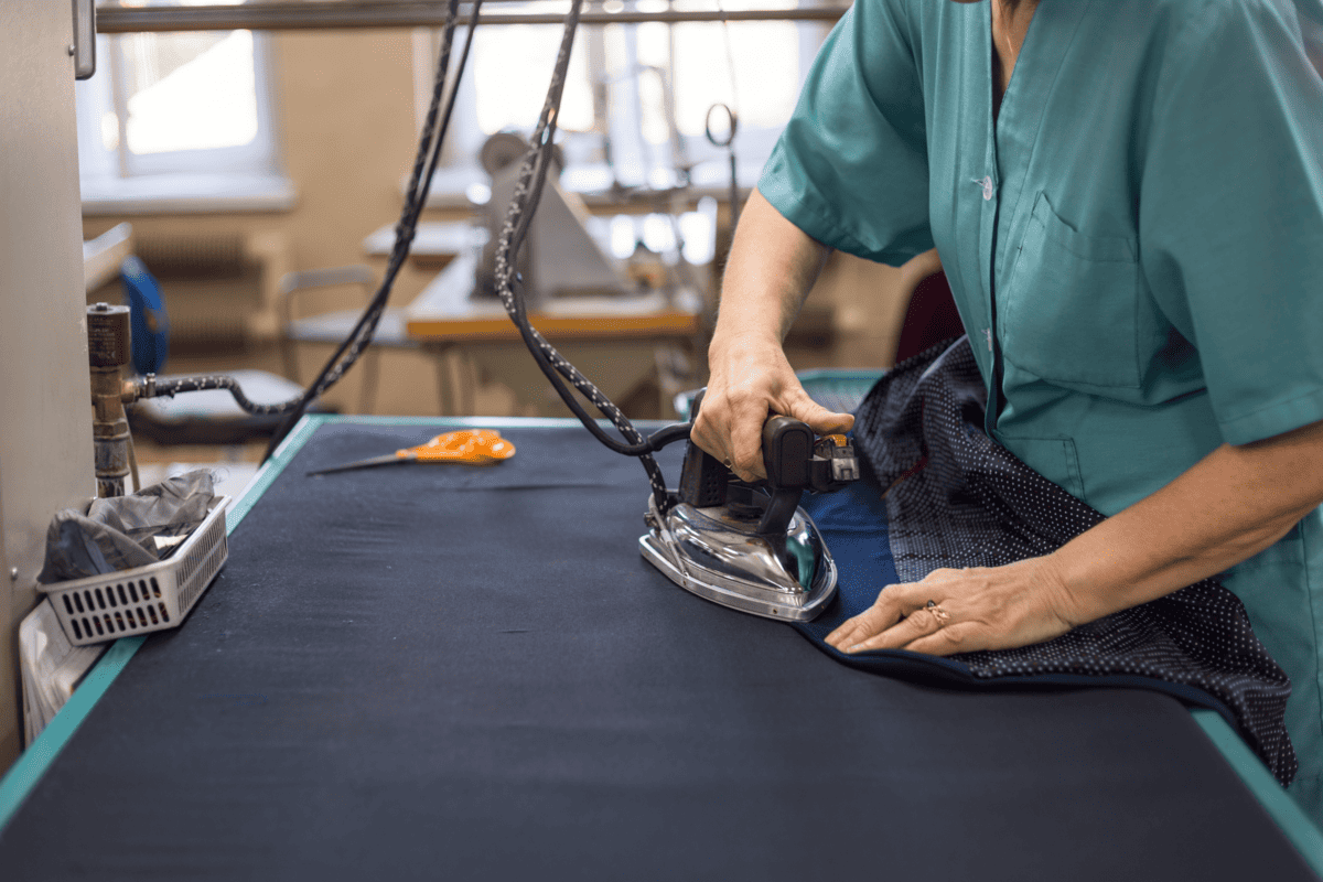 Person ironing fabric on a longboard rectangular ironing board