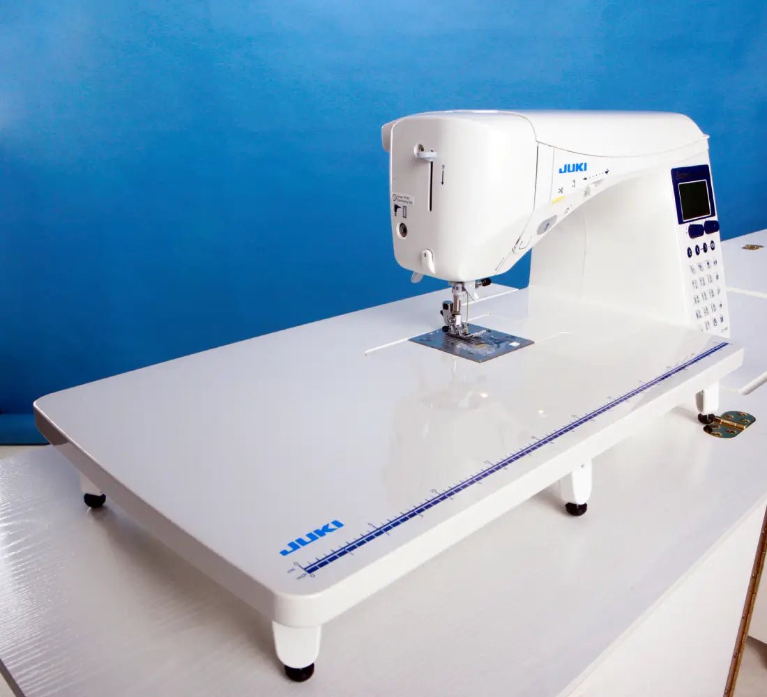 Exceed Quilt & Pro Special HZL-F600 with a white extension table with a blue background