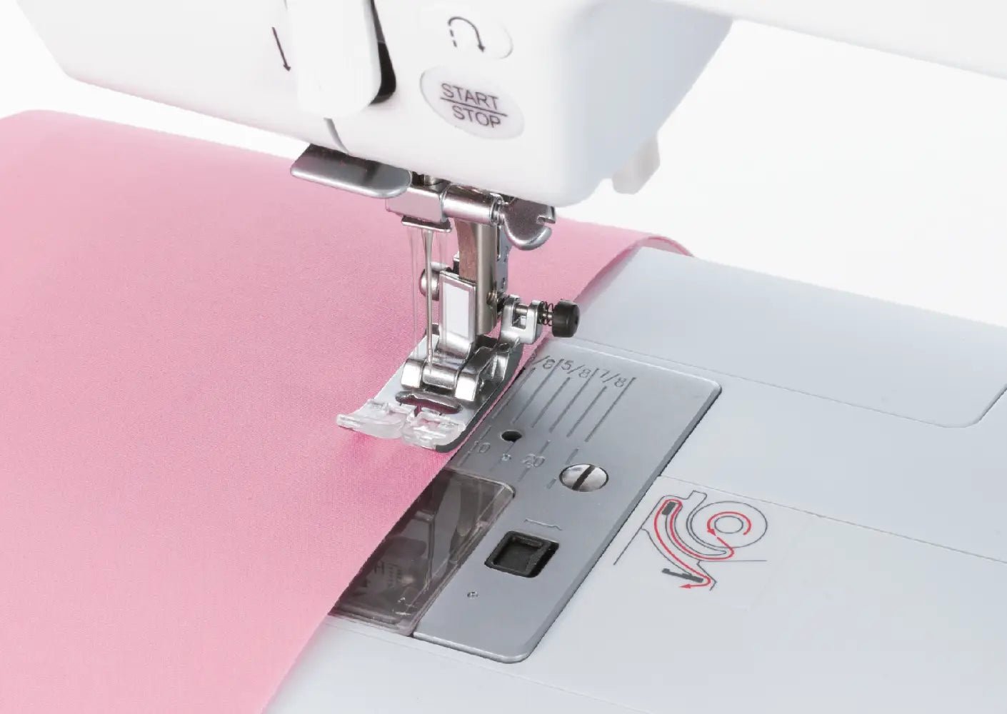 Close-up of a Juki HZL-70HW-A sewing machine needle and presser foot on pink fabric.