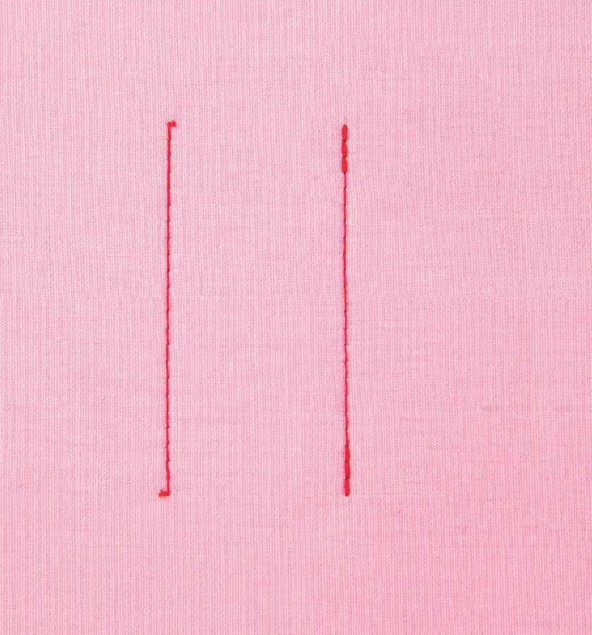 Two vertical red stitches made by a Juki HZL-70HW-A