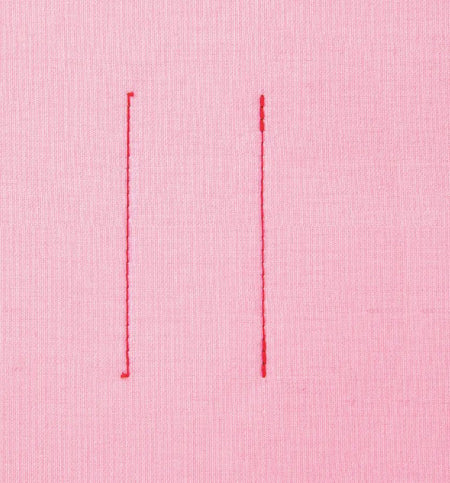 Two vertical red stitches made by a Juki HZL-70HW-A