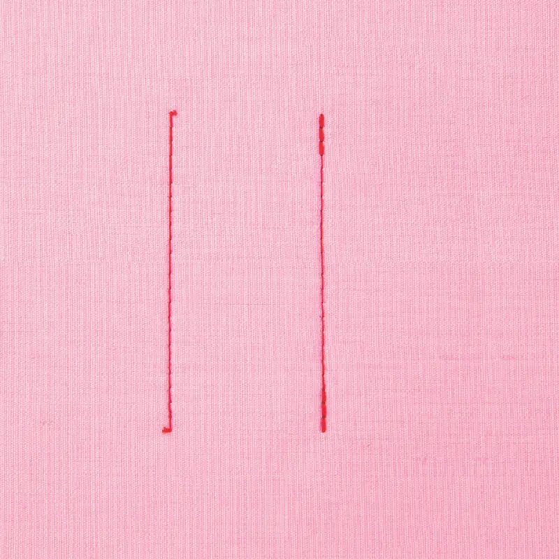 Two vertical red stitches made by a Juki HZL-80HP-A