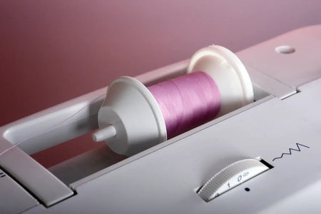 Spool of pink thread in a Juki HZL-353ZR-C Home Sewing Machine