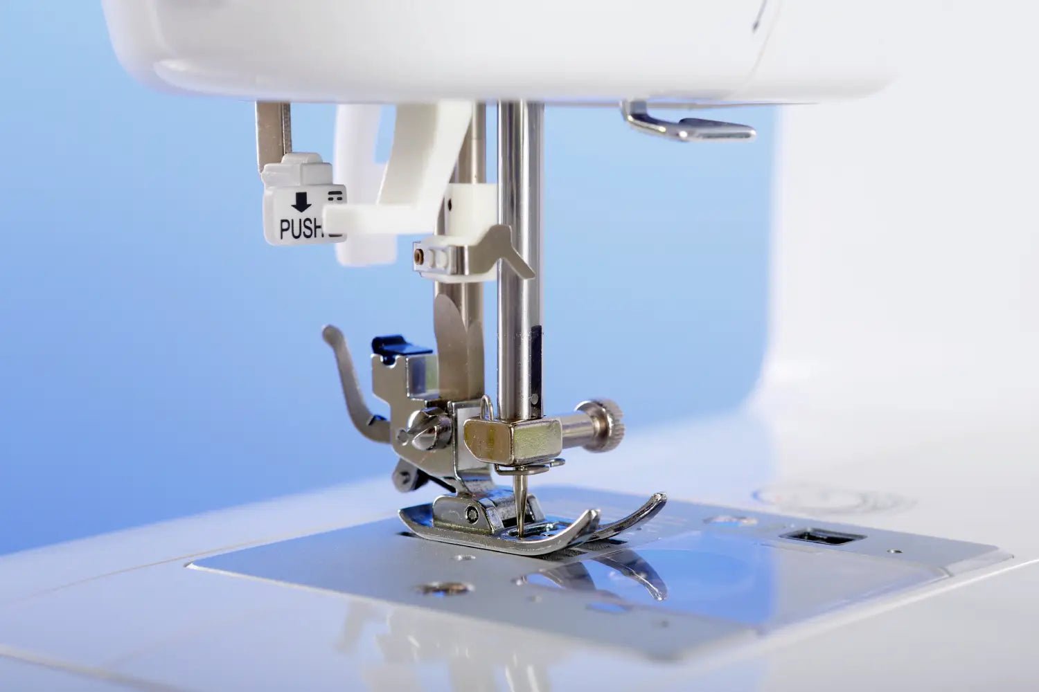 Close-up of a juki HZL-355ZW-A needle plate and presser foot 