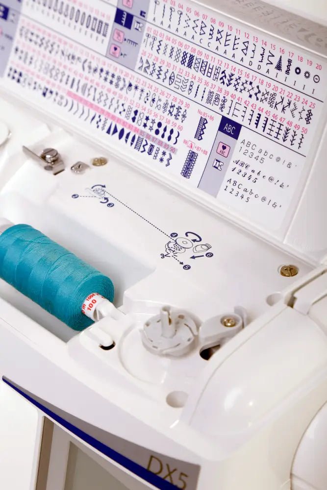 Close-up of a Juki HZL-DX5 with a spool of thread and stitch patterns