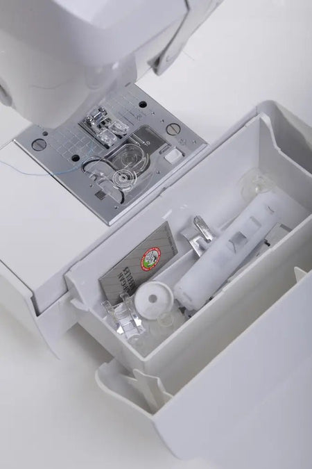 Close-up of a Juki HZL-G120 needle plate and presser foot with storage