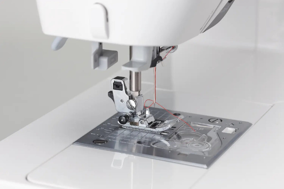 Close-up of a Juki HZL-G220 needle and presser foot on a white background