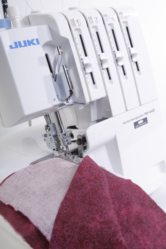 Close-up of a Juki MO-104D sewing red fabric