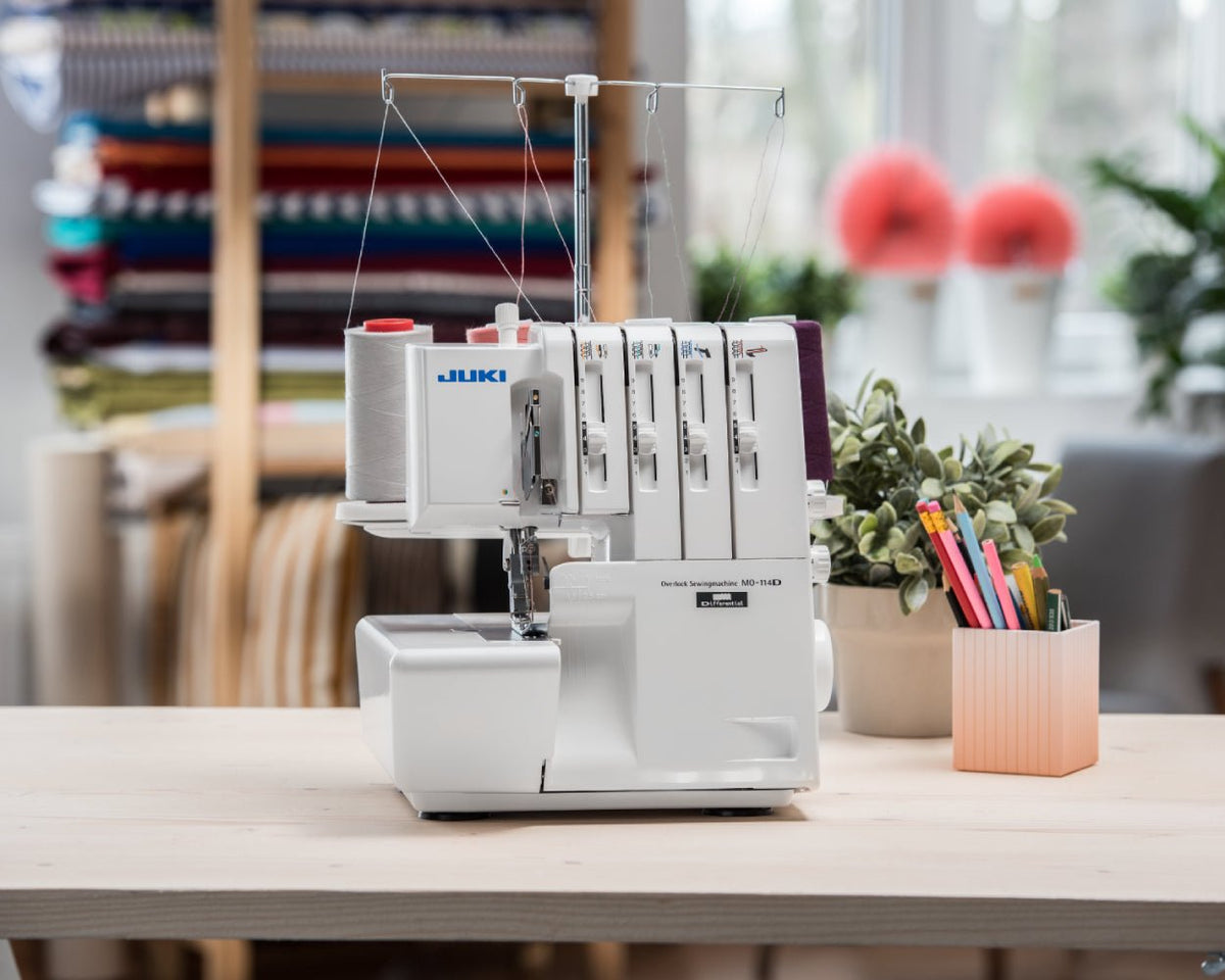 Juki MO-114D sewing machine on a table with a blurred background